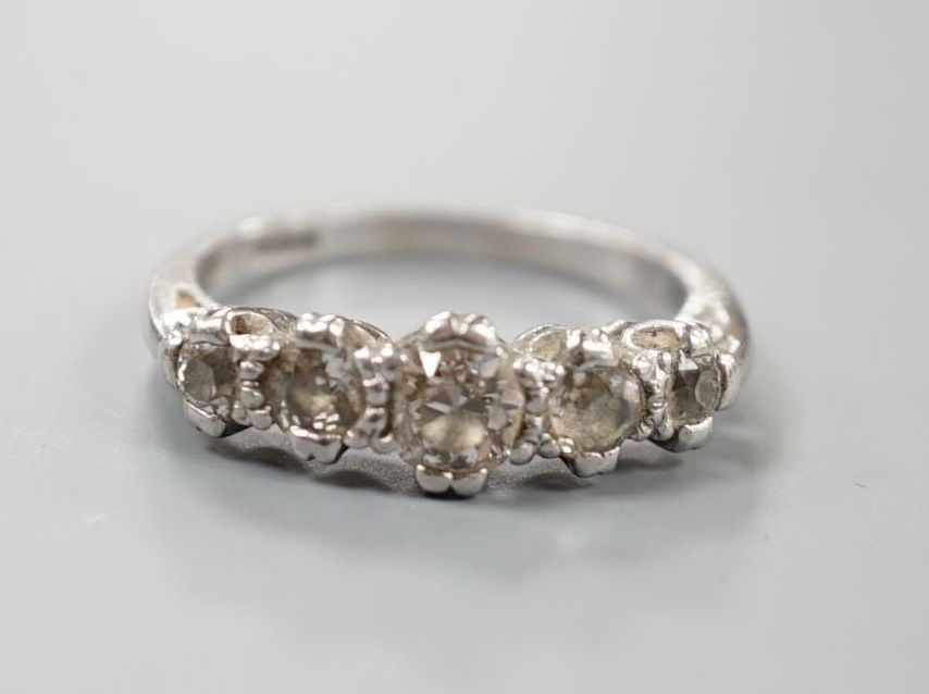 A modern platinum and graduated five stone diamond set half hoop ring, size P/Q, gross weight 6 grams.